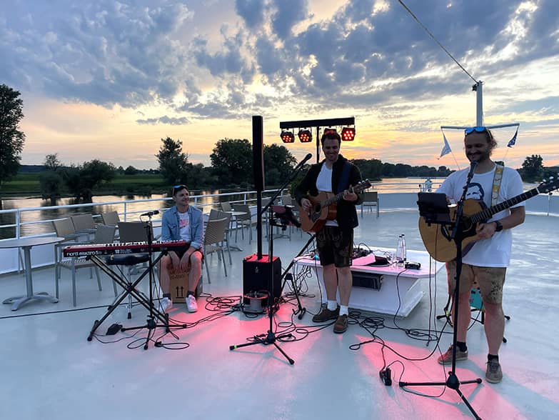 musical group with three people playing at sunset