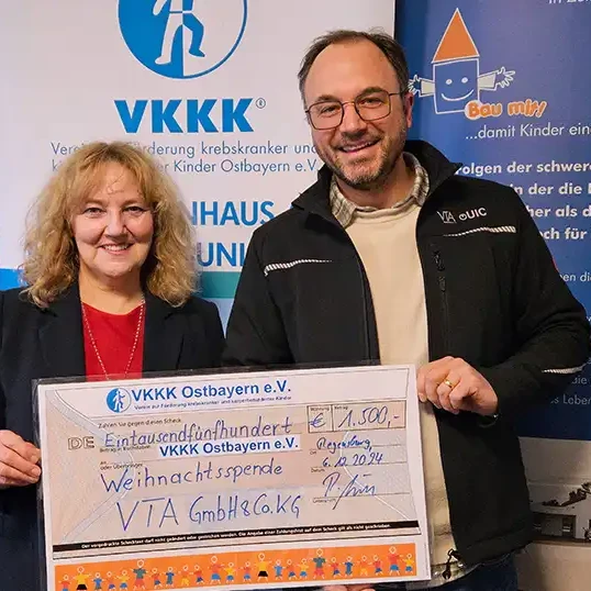 man and woman holding a display check for donation