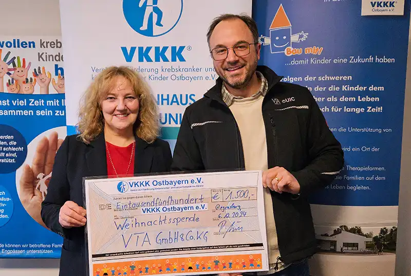 man and woman holding a display check for donation